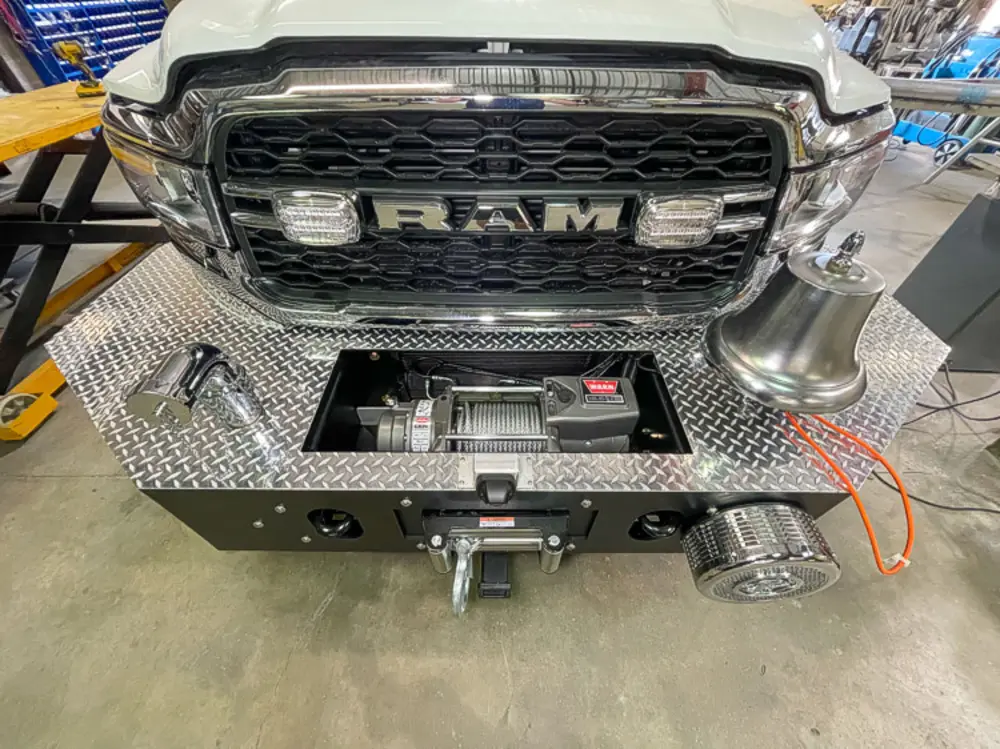 Exterior view of small fire truck showing cab, body compartments, and wheel/tire area.